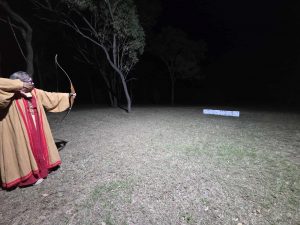 Photo of archer in garb shooting at dice